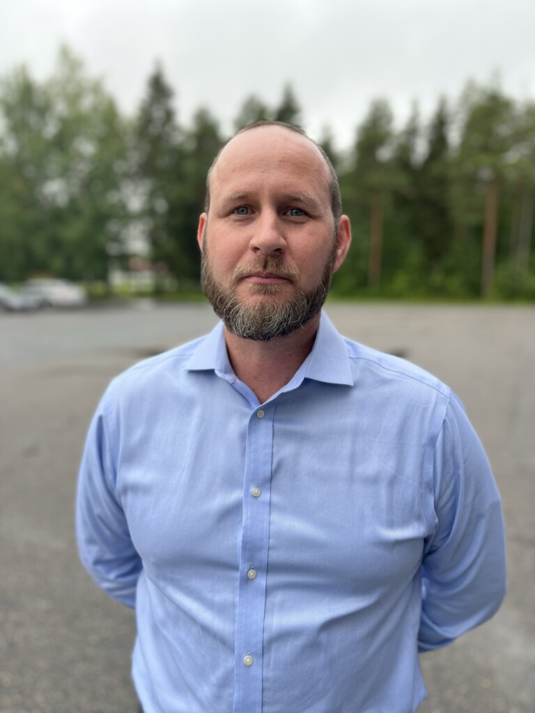 Man standing outside looks towards camera